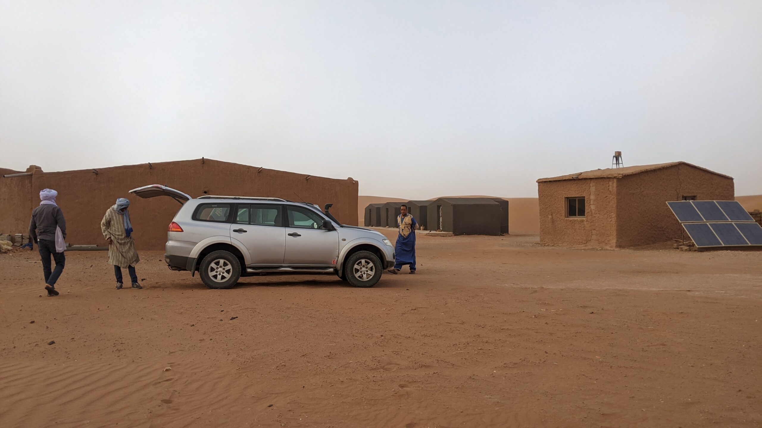 4x4 vehicle beside desert buildings with solar panels