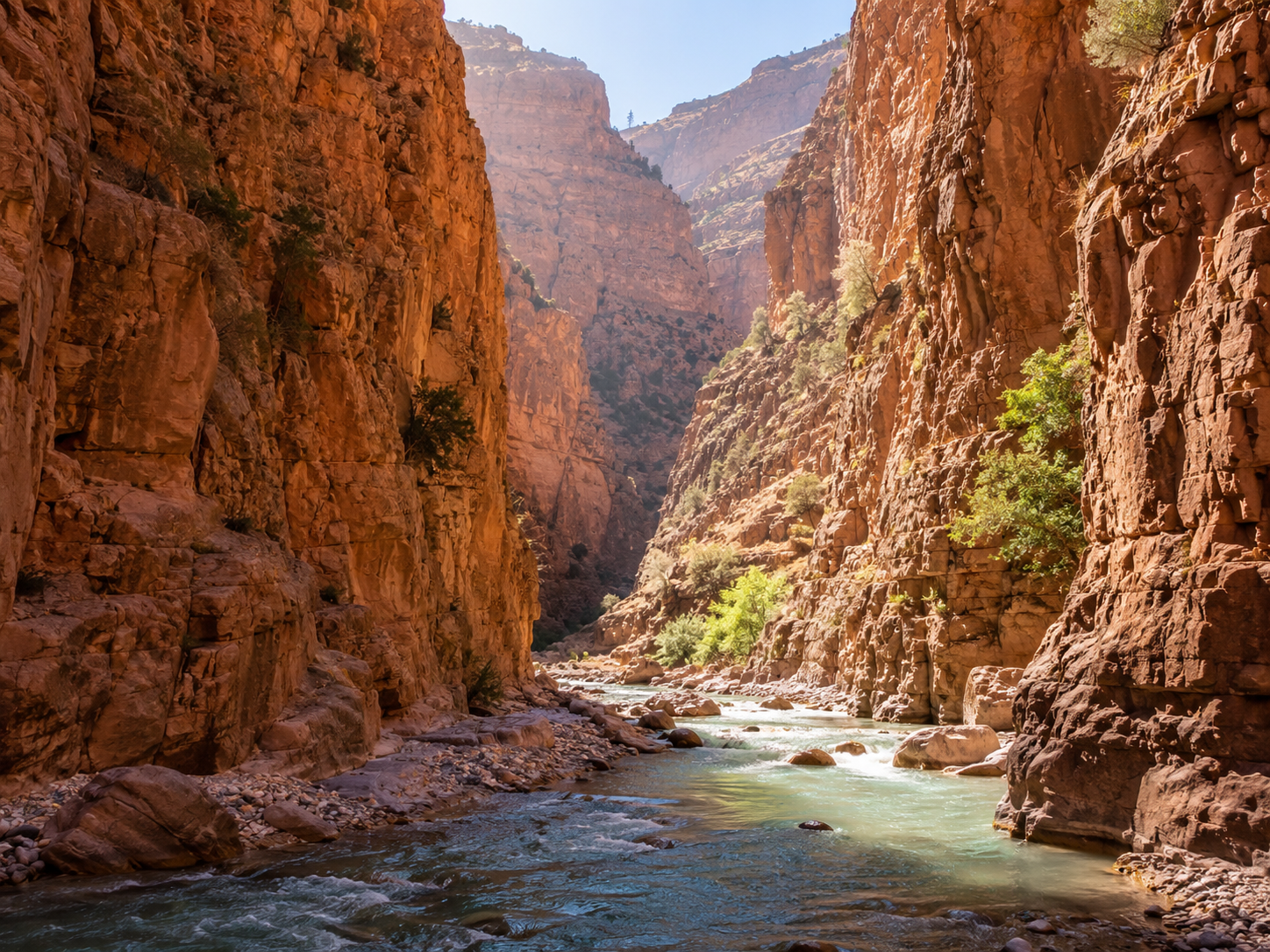 River flowing through a narrow red-rock canyon with steep cliffs